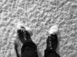 pieds en bottes sur la vue de dessus de neige. bottes et pantalons dans la neige. photo