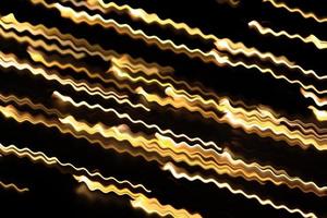 vague de tourbillon rougeoyante jaune, effet de lumière de feu, ligne, décharge électrique de foudre. courbes ondulées brillantes jaunes torsadées. technologie, flux de données sur fond noir isolé photo