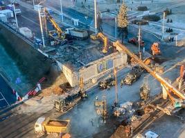 construction d'un pont cassé sur une route très fréquentée. réparation de routes, camions à benne jaune transportant de l'asphalte, du sable pour le pavage photo