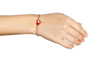 main avec des bracelets en or avec coeur rouge isolé sur fond blanc photo