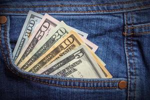 billets en dollars dans la poche de jeans agrandi. notion d'entreprise. argent de poche. photo