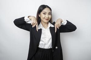 femme d'affaires asiatique excitée portant un costume noir pointant vers l'espace de copie en dessous d'elle, isolée par fond blanc photo