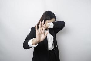 jeune femme d'affaires asiatique isolée sur fond blanc, a l'air déprimée, le visage couvert de doigts effrayés et nerveux. photo