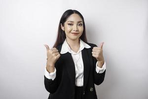 femme d'affaires asiatique excitée portant un costume noir donne le pouce en l'air geste de la main d'approbation, isolée par fond blanc photo