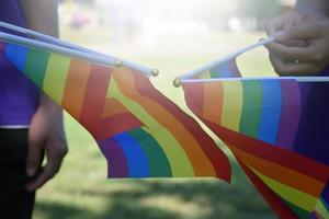 drapeaux arc-en-ciel, symbole lgbt, tenant dans les mains, concept pour la célébration de la communauté lgbt pendant le mois de la fierté, juin 2023, dans le monde entier. photo