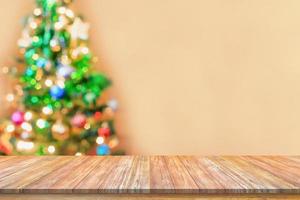 dessus de table en bois vide avec arbre de noël flou avec fond clair bokeh photo