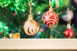 dessus de table en bois vide avec arbre de noël flou avec fond clair bokeh photo