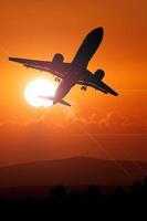 silhouette d'avion de passagers décollant de l'aéroport. avion de passagers dans le ciel au lever ou au coucher du soleil. photo