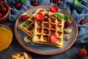 délicieux petit déjeuner avec des gaufres belges. gaufres à la confiture de fraises et de baies photo