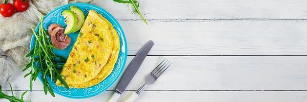 omelette frite au jambon, oignon et herbes. petit déjeuner avec œufs brouillés photo