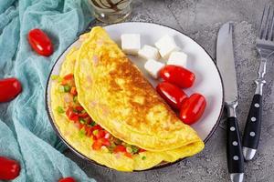 omelette frite au boeuf, tomate, oignon et herbes. délicieux petit déjeuner avec des œufs brouillés photo