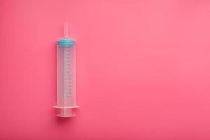 seringue médicale sur cyanure, gros plan sur fond rose, espace de copie. le concept de minimalisme. photo