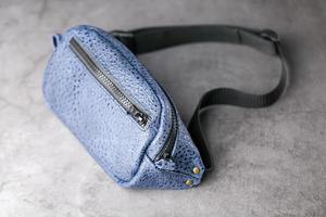 sac banane en cuir bleu, banane sur fond gris. photo