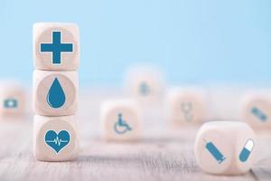 icônes d'émoticônes symbole médical de soins de santé sur bloc de bois, concept de soins de santé et d'assurance médicale photo
