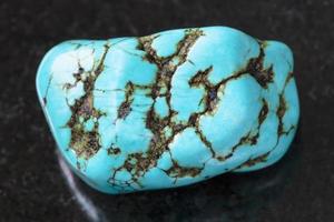 gemme turquoise howlite bleue polie sur dark photo