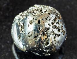 roche d'or de fou de pyrite roulée sur le noir photo