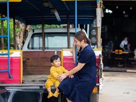 mère asiatique et fils de nationalité thaïlandaise et vieille voiture au café de mala, thung saliam, sukhothai, thaïlande. photo