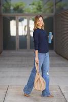 élégante femme souriante et marchant sur le trottoir photo