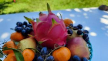 flou, raisins de fruits tropicaux, oranges, fruits du dragon, poires et pommes sur fond blanc photo