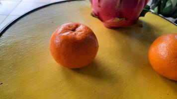 angle supérieur, deux oranges et un fruit du dragon rouge sur un tonneau jaune 03 photo