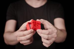 l'homme donne un cadeau dans une boîte cadeau rouge sur st. Saint Valentin photo