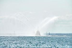 remorqueurs pulvérisant des jets d'eau, démontrant des canons à eau de lutte contre les incendies, pompiers pulvérisant de la mousse photo