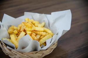 frites sur la table en bois est un fast-food ou de la malbouffe, c'est une collation pour le petit-déjeuner à manger avec du café, du pain ou du poulet frit, c'est de la nourriture malsaine photo