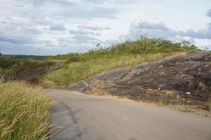 rochers bloquant la route à cause d'un glissement de terrain. glissement de terrain dans une route en béton produit par l'exploitation forestière commerciale et l'abattage d'arbres. rans route provinciale kalimantan est, indonésie. photo