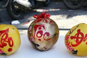 trois pamplemousses décorés pour la célébration du nouvel an vietnamien sur un marché à hoi an, vietnam. l'inscription est traduite - fortune.