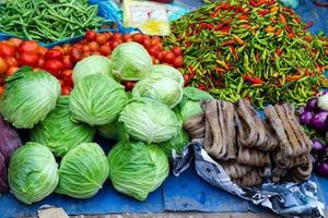 légumes tropicaux frais et calmars séchés sur le marché de rue. marché local du matin à luang prabang, laos.