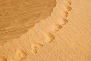 empreintes de pas dans un désert de sable rouge. photo