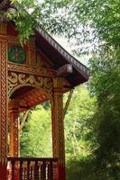 extérieur du temple bouddhiste aux couleurs dorées et rouges parmi la forêt de bambous. luang prabang, laos. photo