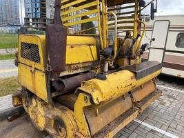 petit rouleau de route jaune puissant pour le pavage d'asphalte et la réparation de routes sur un chantier de construction. machines de construction photo