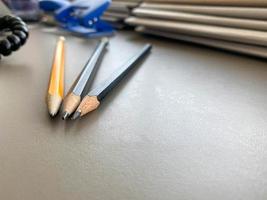trois crayons sont aiguisés à côté de dossiers avec des feuilles de papier et des documents sur le bureau de travail du bureau. papeterie