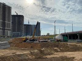 de grands bâtiments et maisons modernes et magnifiques sont des gratte-ciel en béton construits industriellement à l'aide d'une technologie de châssis monolithique à l'aide d'équipements de construction et de grues photo