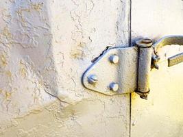 volet de l'ancienne porte de la cabine. logements pour constructeurs. maison temporaire pour les personnes. porte en métal gris attachée à une grande charnière photo