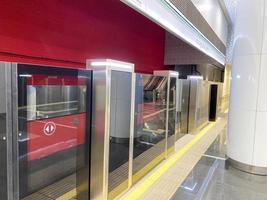 système de plate-forme de porte automatique dans une nouvelle station de métro moderne. système de sécurité du métro de belles portes en verre s'ouvrent de manière synchrone avec les portes de la voiture de train qui arrive photo