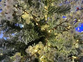 gros plan du sapin de noël avec lumière, flocon de neige. fond de vacances de noël et du nouvel an. ton de couleur vintage photo