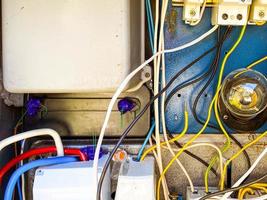 un panneau électrique avec de nombreux fils pour conduire la lumière aux maisons des gens. bouclier fait maison avec une ampoule et des douilles. courant à l'intérieur de la boîte photo