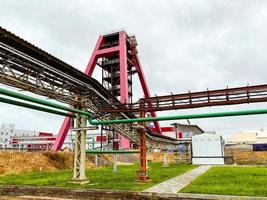 chantier de construction. dans la mine, il y a une grande grue souterraine rouge en métal. à côté d'un gazoduc en métal. extraction de minerais miniers. utilisation des ressources naturelles photo