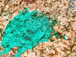 peinture en vrac sur une pièce de métal. la texture est turquoise, entrecoupée de rouille et de trous. pierre peinte, tache sur la texture naturelle photo