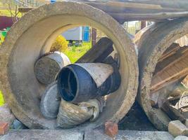 Grands anneaux de construction en ciment de béton pour un puits ou un égout avec des débris industriels à l'intérieur photo