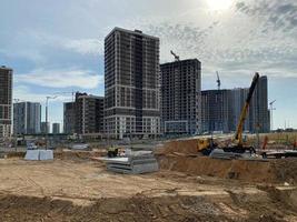 de grands bâtiments et maisons modernes et magnifiques sont des gratte-ciel en béton construits industriellement à l'aide d'une technologie de châssis monolithique à l'aide d'équipements de construction et de grues photo