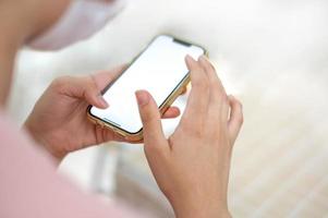 main féminine utilisant un téléphone portable intelligent pour les appels, les médias sociaux, la navigation sur le Web mobile ou les achats en ligne. photo