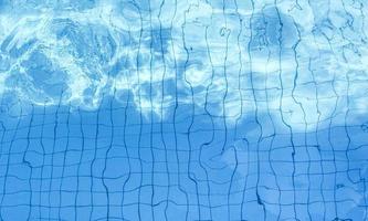 motif de vague d'eau bleue dans la piscine alors que le soleil brille pendant la journée. mise au point douce et sélective. photo