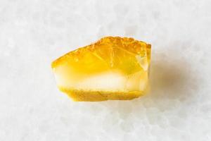 pierre précieuse d'ambre jaune non polie sur marbre blanc