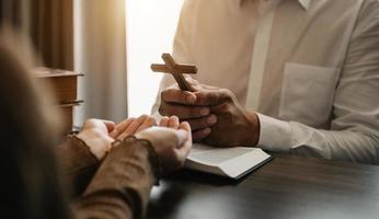 main de femme avec croix. concept d'espoir, de foi, de christianisme, de religion, d'église et de prière à dieu. sur la table photo