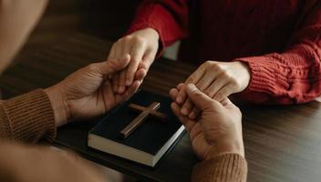 deux personnes lisent et étudient la bible à la maison et prient ensemble.étudier la parole de dieu photo