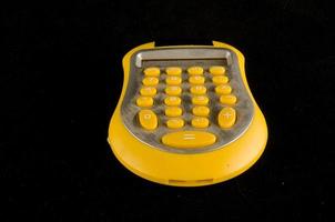 calculatrice jaune sur fond noir photo