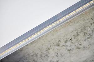 bande lumineuse led avec profil en aluminium sur plafond tendu, gros plan. concept de rénovation domiciliaire photo